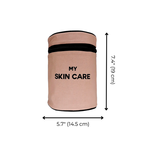 Bag-all Round My Skin Care Case in pink blush, cylindrical organizer with black zipper, laminated interior and organizational pockets, measures 7.4 x 5.7 inches