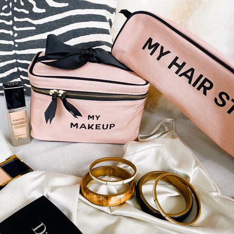 Bag-all Hair Stuff Travel Case in blush pink with black bow detail and gold zipper, shown with matching makeup case and accessories. Heat-resistant thermal lined organizer for styling tools.