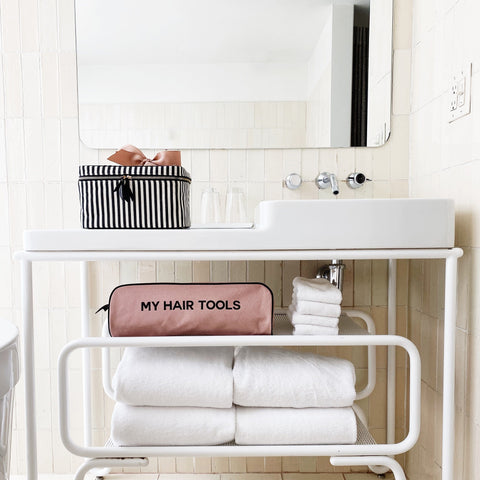 Bag-all Roomy Hair Wrap Tools Travel Case in pink blush displayed on white bathroom shelf with towels, perfect for organizing styling tools and Airwrap storage