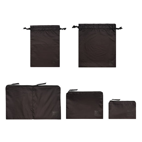 Bag-all Packing Bags Set in recycled nylon featuring 5 black organizer bags - two drawstring pouches and three zippered cases in varying sizes for efficient travel storage and organization