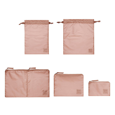 Bag-all Packing Bags Set in recycled blush pink nylon featuring 5 organizational bags - double compartment case, medium pouch, small case, and two drawstring bags for travel and storage