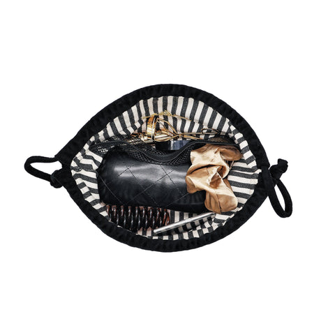 Black velvet drawstring makeup bag by Bag-all open showing organized essentials inside with striped interior lining