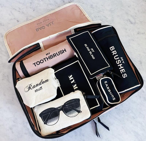 Bag-all Pink Toothbrush Travel Case featuring organized compartments for multiple toothbrushes and toiletries, showcased with sunglasses and travel essentials on marble background