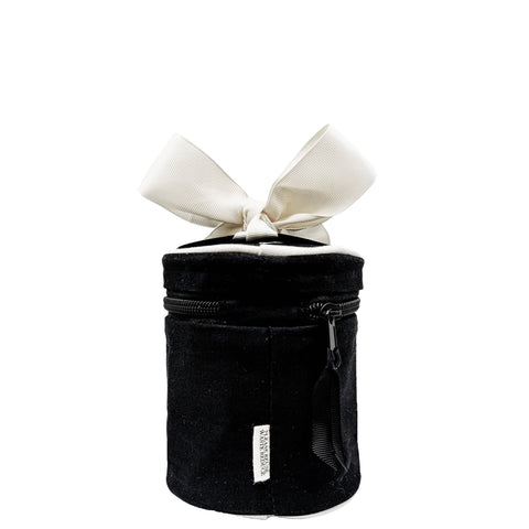Black round carry-on liquids case with zipper and large cream bow on top, travel bottles included and monogrammed tag visible