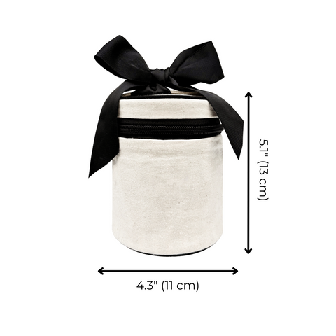 Cream-colored round carry on liquids case with black zipper and bow, measuring 5.1 by 4.3 inches for travel organization.