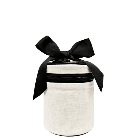 Cream round carry on liquids case with black zipper and large black bow tied on top