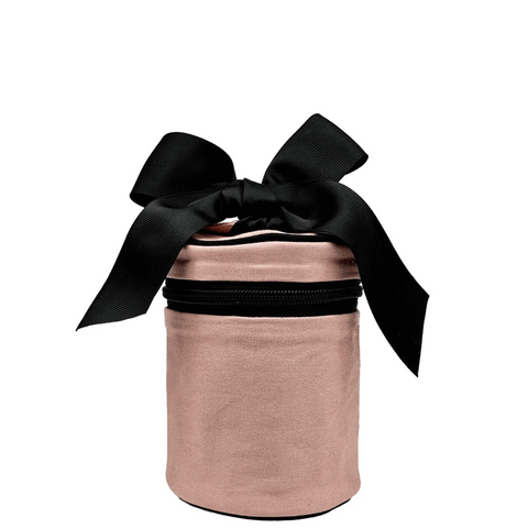 Pink blush round carry on liquids case with black zipper and decorative black bow on top, travel-sized and TSA compliant.
