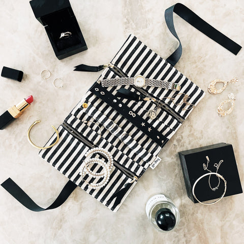 Bag-all Jewelry Organizer Travel Pouch in cream with black striped interior, featuring multiple compartments, leather earring holder, and padded ring section for secure jewelry storage