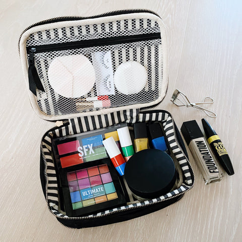 Bag-all Double Sided Toiletry Case in Black featuring waterproof interior, dual compartments with elastic straps, shown open displaying makeup and beauty products with striped lining and mesh organization panel