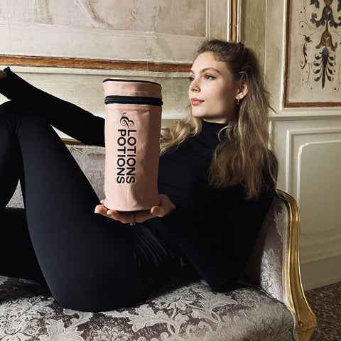 Bag-all Lotions & Potions Travel Case in blush pink, cylindrical waterproof organizer for toiletries and beauty products. Stylish striped interior, perfect for travel or home storage.