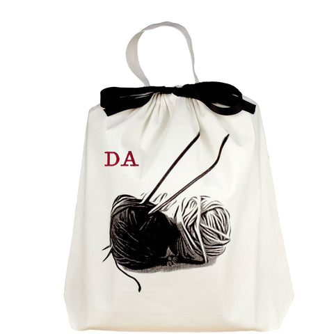 Bag-all Cream Knitting Bag with black and white yarn ball design and monogram option, featuring black bow and carrying handle for portable craft storage