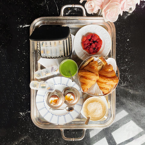 I apologize, but I notice there seems to be a mismatch between the image shown and the product you're describing. The image appears to be of a breakfast or brunch setting with croissants, berries, drinks and other food items on a serving tray, rather than a pill organizer case. Would you like me to create alt text for the breakfast tray image shown, or would you prefer to provide an image of the pill organizer case instead?