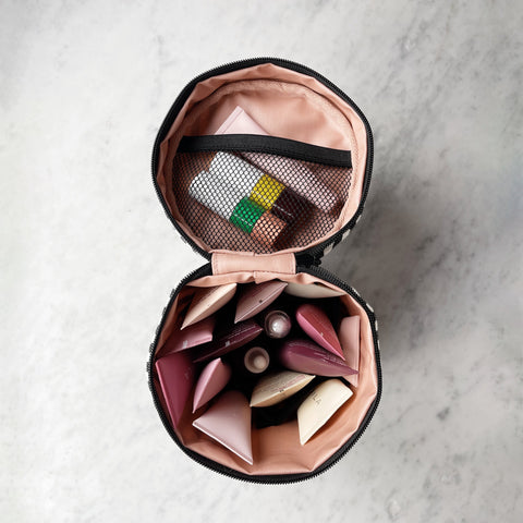 Bag-all Round My Skin Care Case Striped with blush pink interior, mesh pocket, and multiple compartments for organized skincare storage, shown open on marble surface
