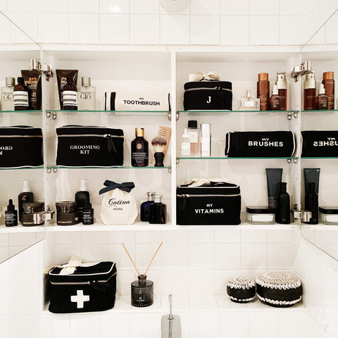Bag-all Black Vitamins Storage and Travel Box displayed in organized bathroom cabinet alongside matching toiletry cases and grooming essentials on white shelving