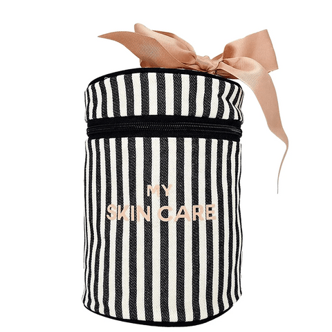 Bag-all Round Skin Care Case with Handle featuring black and white vertical stripes, pink bow accent, and metallic gold lettering. Cylindrical travel organizer with zipper closure.