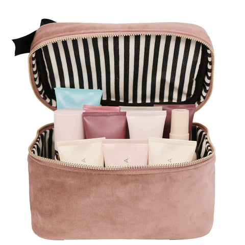 Bag-all My Makeup Cosmetic Box in Pink Velvet featuring striped interior lining, waterproof compartments, and generous space for beauty products. Luxurious velvet exterior with zip closure and black bow detail.