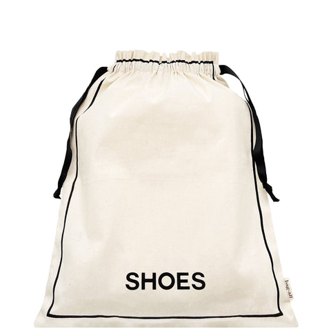 Bag-all Couture Shoe Travel Bag in cream canvas with black drawstring closure and 'SHOES' text print, perfect for organized footwear storage and travel