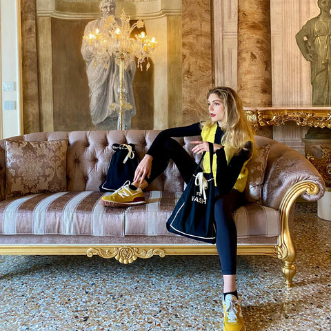 Bag-all To Wash Laundry Bag in black showcased on elegant vintage sofa, styled with yellow accents in luxurious interior with crystal chandelier and marble columns