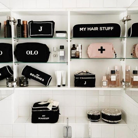 Bag-all Hair Stuff Travel Case in black displayed in organized bathroom shelf with other matching beauty cases, featuring heat-resistant design for styling tools and accessories