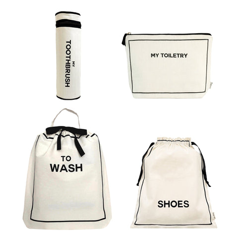 Bag-all Toiletry Travel Gift Set 4-Pack in cream featuring toothbrush holder, toiletry pouch, wash bag, and shoe bag, all made from natural cotton with black text labels