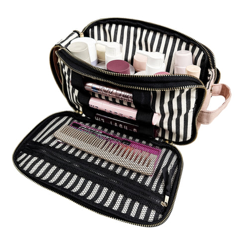 Striped triple compartment beauty and toiletry organizer open with makeup and skincare products inside