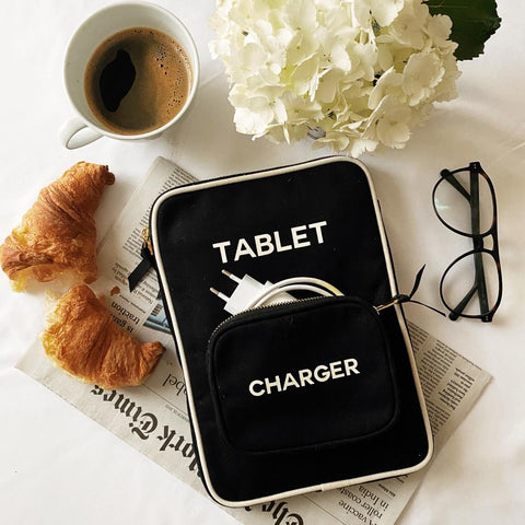 Bag-all Tablet Case 11" in black with charger pocket, styled with coffee, croissants, white hydrangeas and reading glasses on newspaper backdrop