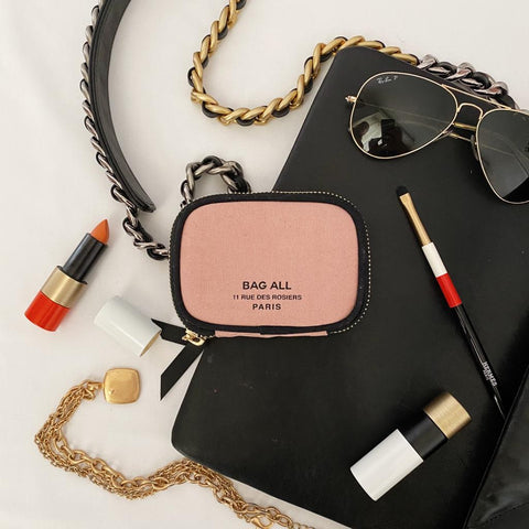 Bag-all Small Wallet Pink/Blush with Black Piping featuring stylish gold zipper and chain strap, displayed with sunglasses, lipstick, and beauty essentials in a chic flatlay composition