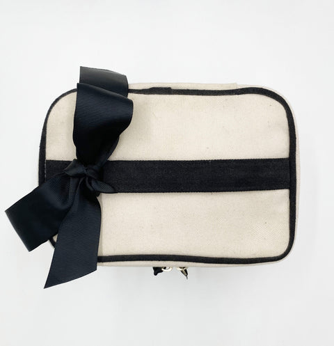Bag-all Meds and First Aid Storage Box in cream canvas with black trim, decorative bow, and zipper closure - stylish medical supply organizer with handle