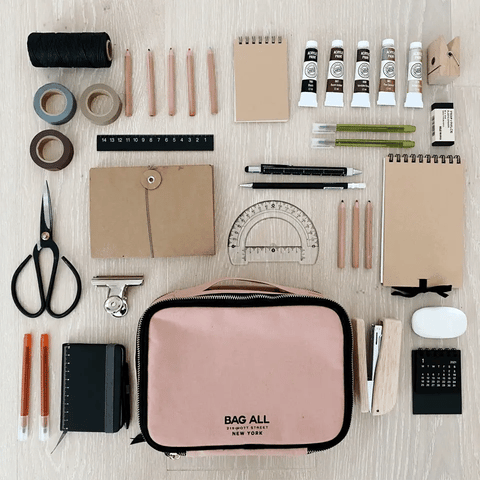 Bag-all Weekend Packing Set 3-Pack in Pink/Blush with art supplies, including scissors, rulers, notebooks, and writing tools arranged in a minimalist flat lay composition