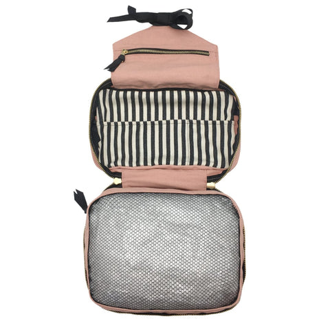 Bag-all Folding Toiletry Case in blush pink with striped interior compartment and mesh storage, featuring hanging ribbon and multiple organizing sections for travel essentials