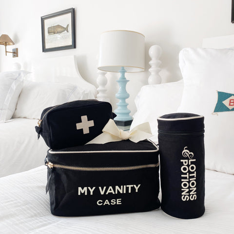 Black Beauty Gift Set 3-Pack with My Vanity Case, First Aid Pouch, and Lotions & Potions Case on a white bed.
