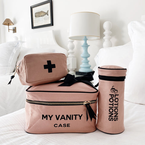 Pink/Blush Beauty Gift Set 3-Pack with My Vanity Case, First Aid Pouch, and Lotions & Potions Case on a white bed.