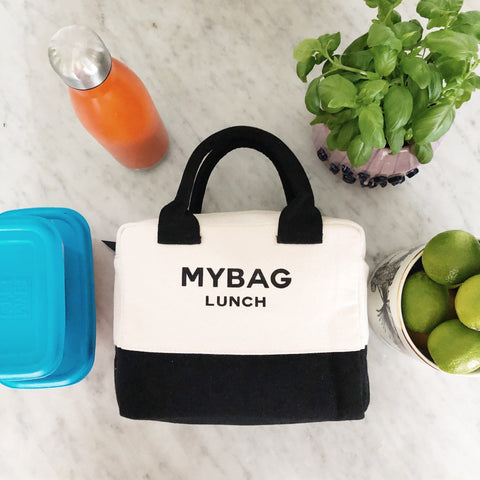 Bag-all Lunch Box Insulated in cream and black with contrast piping, featuring text MYBAG LUNCH, shown with fresh produce and drink bottle on marble surface