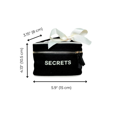 Bag-all Mini Beauty Box for Secrets in black cotton with white bow, metal zipper, and waterproof lining. Perfect for travel-sized items and personal treasures. Size: 5.9x4.13x3.15 inches.