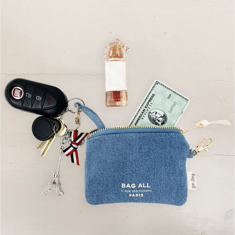Bag-all Mini Trinket Pouch in Denim shown with car keys, credit card and perfume vial, displaying practical everyday essentials storage with Eiffel Tower charm accent