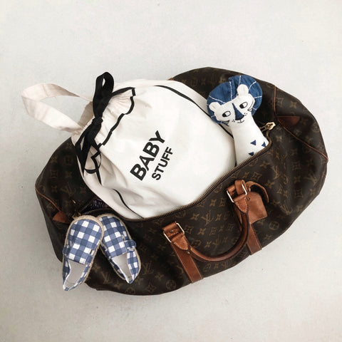 Bag-all Baby Couture Bag in Cream inside a travel duffel. Perfect for organizing baby essentials on the go, featuring a chic drawstring design