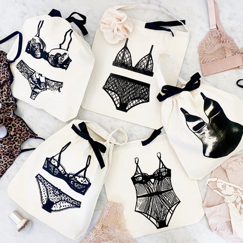 Bag-all Polkadot Lingerie Travel Bag in cream with black ribbon ties featuring stylish lingerie illustrations, perfect for organizing delicates while traveling or at home