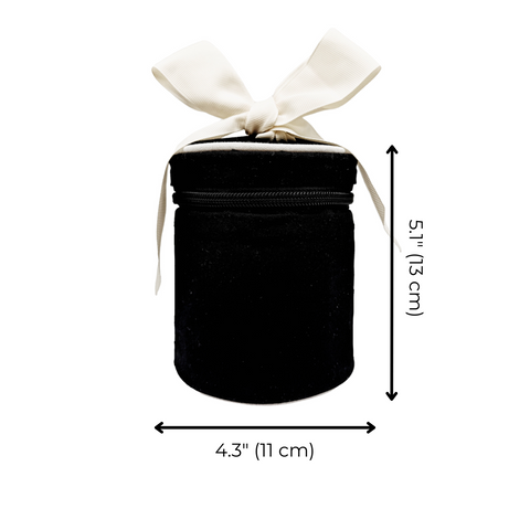 Black round carry on liquids case with white bow, measuring 5.1 by 4.3 inches, travel bottles included, monogram option.