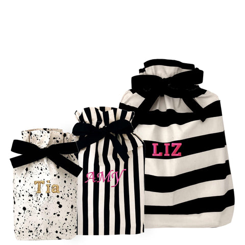 Bag-all Gift Bags Set Mix 2 featuring personalized fabric bags with striped and splatter patterns in black and white, showcasing monogrammed names Tia, Amy, and Liz