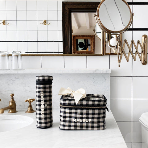 Bag-all Gingham Toothbrush Travel Case, stylish black and white checkered fabric organizer on marble countertop, paired with matching makeup case in bathroom setting