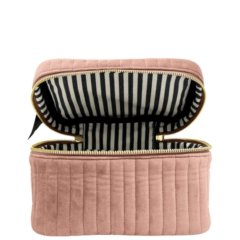 Quilted pink velvet makeup cosmetic box with gold zipper and black-and-white striped interior lining open view.