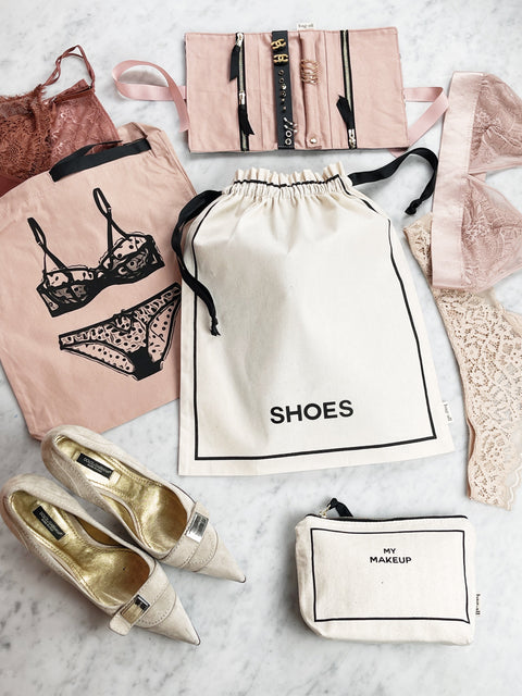 Bag-all Couture Shoe Travel Bag in cream with small print, displayed with designer shoes and matching travel organizers, showcasing elegant storage solution for footwear protection and organization