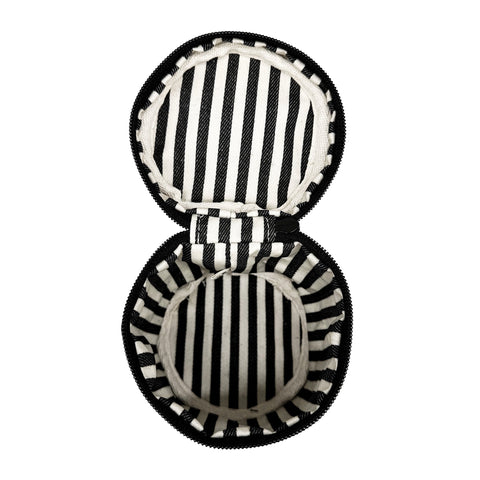 Open round black and white striped carry on liquids case with zipper and padded interior for travel bottles
