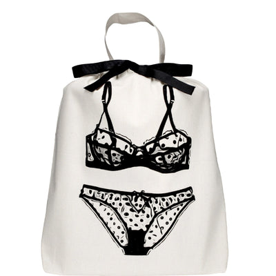 Bag-all Polkadot Lingerie Travel Bag in cream cotton featuring black illustrated polka dot bra and panty set design with ribbon tie closure and carrying handle